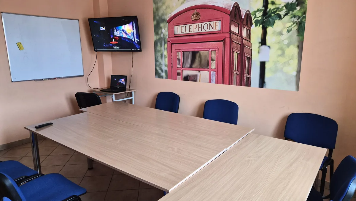 Sala kameralna dla 8-10 osób z telewizorem, tablicą suchościeralną i fototapetą z londyńską budką telefoniczną